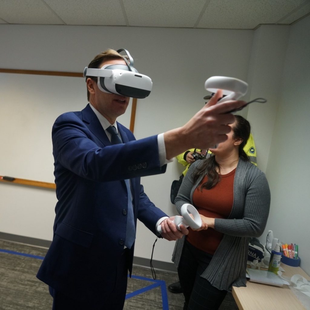 U.S. Senator Chris Murphy (D-Conn.) trying his hand at VRNA, a virtual reality training system for nurse aides, while visiting VRSim, Inc. in East Hartford, CT on Wednesday, January 4, 2023. Photo credit: Jameson Foulke.