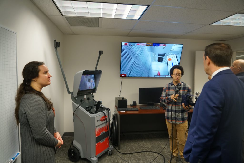 VRSim, Inc. staff (left to right) Sara Blackstock and Alejo Fudge, demonstrating SimSpray®, a virtual reality training system for painting and coatings, for U.S. Senator Chris Murphy (D-Conn.) during a visit to VRSim, Inc. in East Hartford, CT on Wednesday, January 4, 2023.